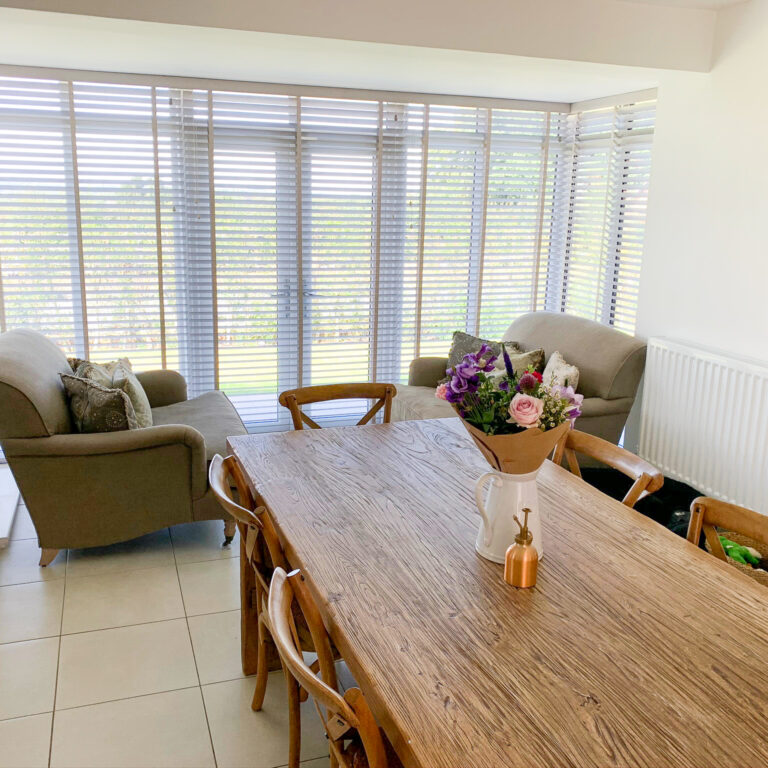 Natural wood Venetian blinds on patio doors in a dining room in Medstead Hampshire