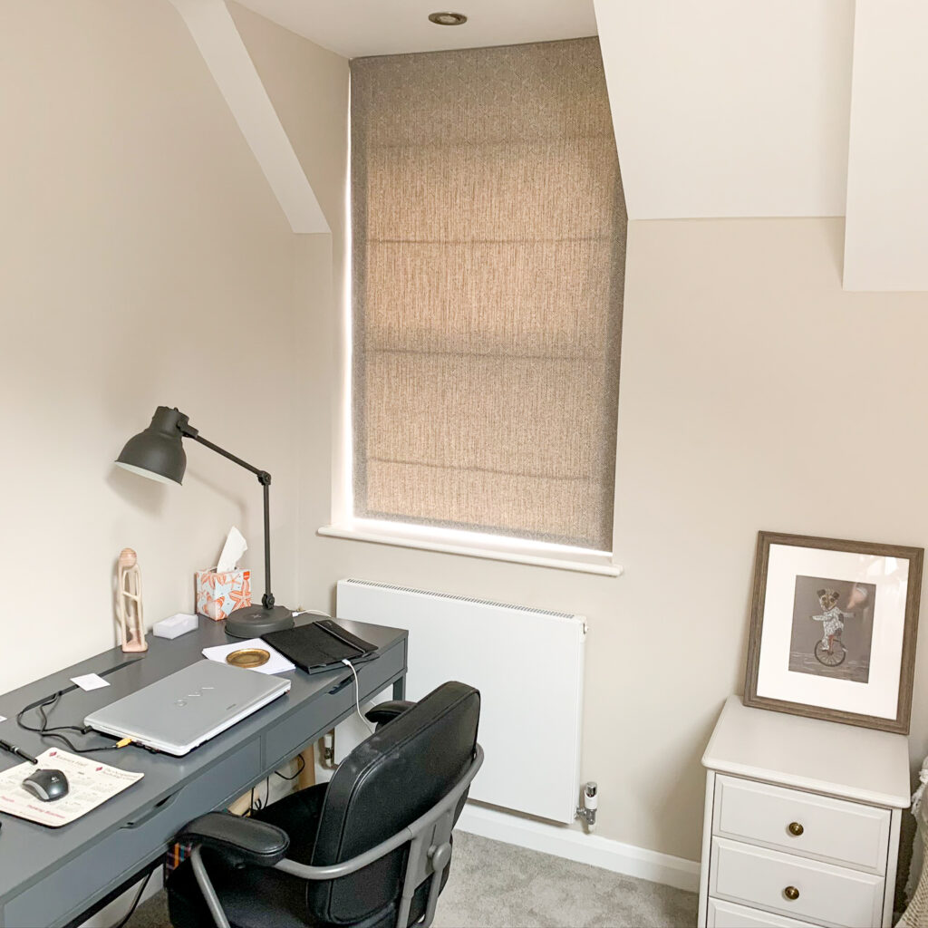 Beige Roman blind in a study