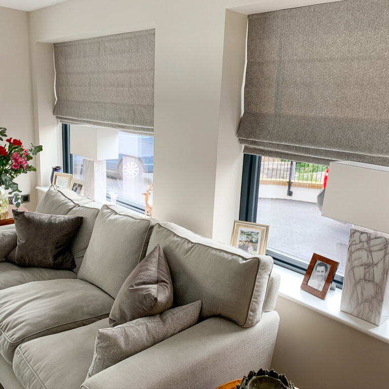 Grey Roman blinds in living room windows